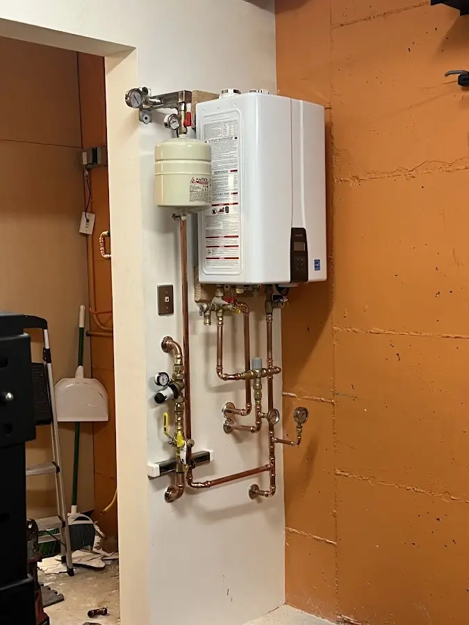 Plumbing technician inspecting water heater connections in Jefferson City